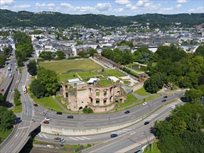 Aerial view of historical ruins in a city with neighbouring street network and spacious park,