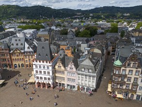 Historic, colourful buildings on a busy market square with pedestrians in the old town of Trier,