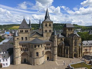 Historic cathedral with many towers under a clear sky and white clouds in Trierr, aerial view,