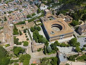 Historic city with striking round building, surrounded by trees and streets, bird's eye view in