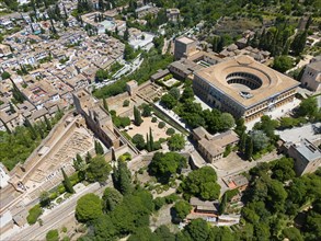 Aerial view of a historic city with fortress and palace, surrounded by lush greenery and brick