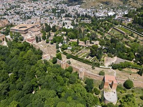 Aerial view of a castle complex surrounded by green vegetation and urban landscape, aerial view,