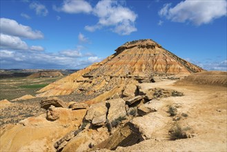 Large hill with stony structure in a desert-like landscape under a blue sky, Bardenas Reales