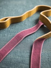 Colorful fabric ribbons laid out on a blue textured background, AI generated