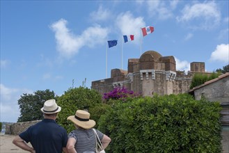 Two tourists stand in front of the citadel of Saint-Tropez, built in 1602 as a defence against the