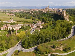 Aerial view of a medieval town with castles and green surroundings in a hilly valley, aerial view