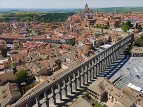 Historic aqueduct crosses a densely built-up urban area, aerial view, some buildings with modern