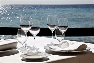 Diano Marina, 13.10.2009, Table set with wine glasses and napkins in a restaurant by the sea,