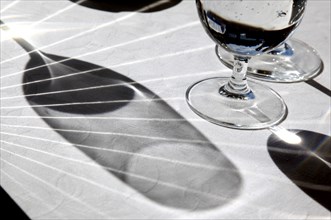 Diano Marina, 13.10.2009, Wine glasses and a wine cooler cast shadows on a laid table, Italy,