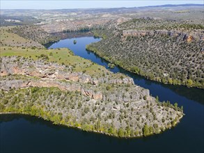 Expansive view of a river winding through deep gorges and a mountainous landscape, aerial view,