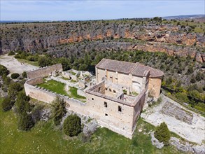 Historic ruin in a rocky landscape with river and dense vegetation, bird's eye view, aerial view,