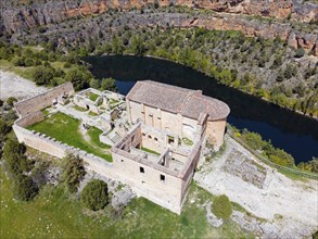 Historic ruin in a rocky landscape with river and lush vegetation, bird's eye view, aerial view,