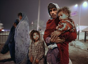 New Delhi, India, 21.01.2010, A homeless family searches for a place to sleep under a bridge,