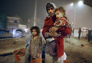 New Delhi, India, 21.01.2010, A homeless family searches for a place to sleep under a bridge,