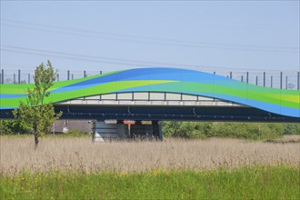 Colourfully painted motorway bridge with noise barrier over the river Este, Buxtehude, Altes Land,