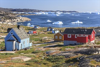 Typical Greenlandic houses, Inuit settlement in front of icebergs, Qeqertaq, Disko Bay, West