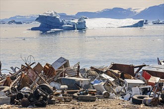 Rubbish dump, waste, electronic waste in front of icebergs in fjord, environmental pollution,