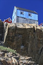 Typical Greenlandic house on a rock, sunny, Uummannaq, West Greenland, Greenland, North America