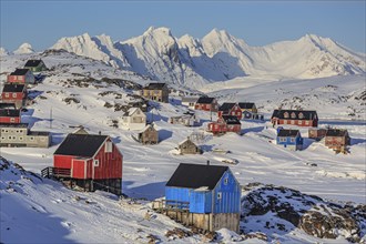 Typical Greenlandic houses in front of snowy mountains, Inuit settlement, winter, Arctic, Kulusuk,