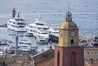 View of the Notre-Dame de l'Assomption church, behind it yachts in the harbour, Saint Tropez,