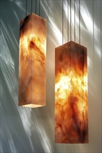 Vertical, rectangular marble hanging lamps casting a warm light, exhibiting artistic and modern