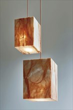 Two elegant, modern, cube-shaped marble hanging lamps with a soft glow, AI generated