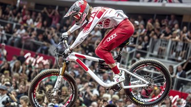 A biker in action during a competition, showcasing an impressive jump in front of a large crowd,