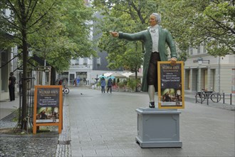 Sculpture of Johann Wolfgang von Goethe in historical clothing and poster signposting the way to