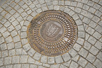 Round manhole cover with town coat of arms, paving stones, floor, Sondershausen, Thuringia,