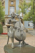 Musicians' fountain with cello player by Bonifatius Stirnberg 1989 in front of the blue town hall,