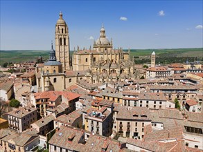 View of a medieval city with a prominent church and historic buildings nestled in a landscape under