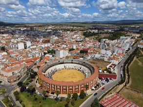 Aerial view of a city with a centrally located bullring under a cloudy sky, aerial view,