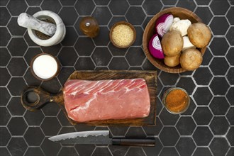 Overhead view of raw pork fillet, fresh champignons and spice ready for cooking