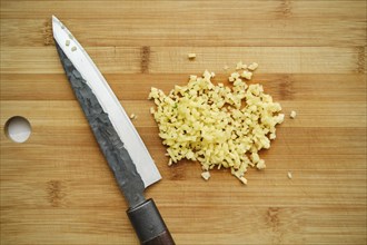 Overhead view of chopped ginger on cutting board