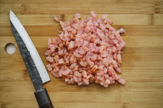 Overhead view of roughly chopped shrimps on cutting board