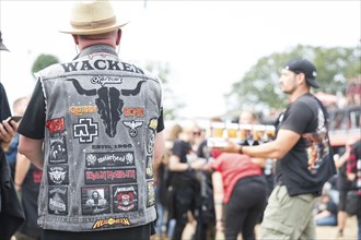 Visitors wearing Wacken waistcoats and beer at the Wacken Open Air in Wacken. The traditional metal