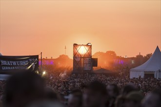 Sunset behind tower with banner Faster Harder Louder at the Wacken Open Air in Wacken. The