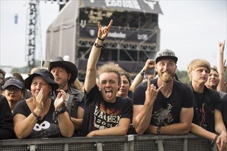 Festival visitors give the devil's salute at the Wacken Open Air in Wacken. The traditional metal