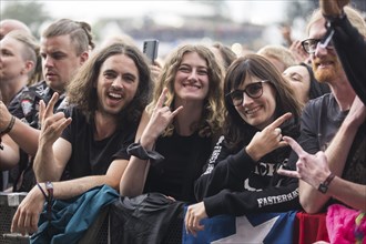 Festival visitors give the devil's salute at the Wacken Open Air in Wacken. The traditional metal