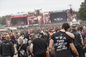 Kissing couple in front of the main stages at the Wacken Open Air in Wacken. The traditional metal