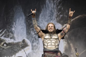 Captain Feuerschwanz, singer of the band Feuerschwanz, shows the metal salute at the Wacken Open