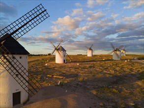 Several windmills in a rural landscape under a slightly cloudy evening sky, aerial view, windmills,