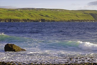 Rugged coastline with cliffs and waves, green hills in the background, Doolin, Cliffs of Moher,