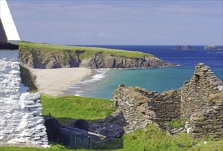 Stone ruins and farmhouse on a rocky coast with sandy beach, Blasket Islands, Dunmore Head,