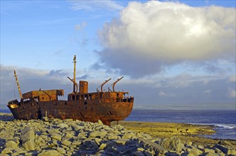 Rusty shipwreck on rocky coast with big sky, Arran Islands, Ireland, Europe