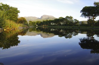 Calm by the lake with tree and mountain reflections on the water surface, Caledonian Channel, Fort