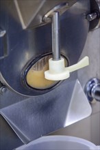 Close-up of a machine dispensing ice cream mix during production