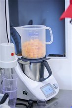 A modern blender being used to chop and measure fruits in a kitchen