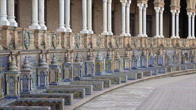 Colourful azulejos, colonnade and tiled benches of the pavilion at the Plaza de Espana in Seville,