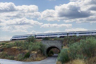 Moving train passing over a tunnel, cloudy sky in the background